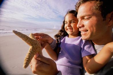 Close-up of a man showing his daughter a starfish